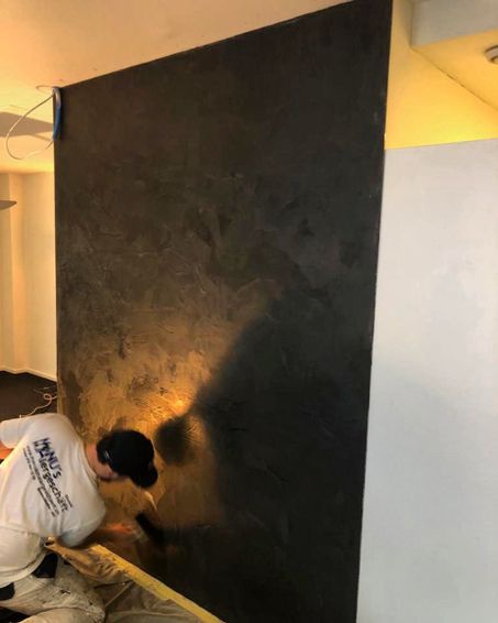 Maler der Manu's Malergeschäft AG arbeitet an einer Wand