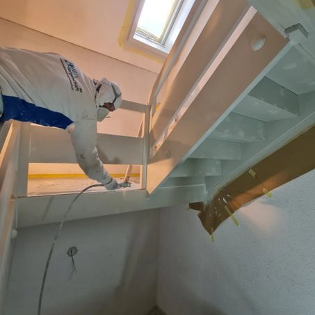Maler der Manu's Malergeschäft AG arbeitet an einer Treppe