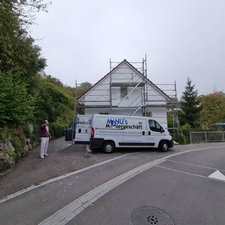 Fahrzeug der Manu's Malergeschäft AG vor einem Haus